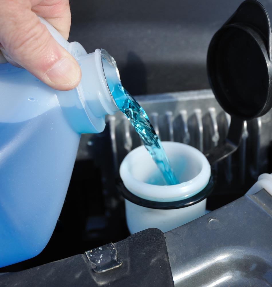 Pouring screenwash into a car